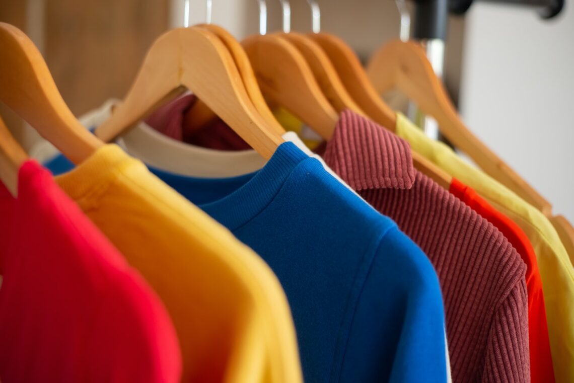 Kolorowe ubrania wisza na wieszaku w szafie
